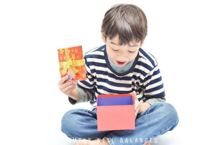 4 year old boy opening gift, surprised.