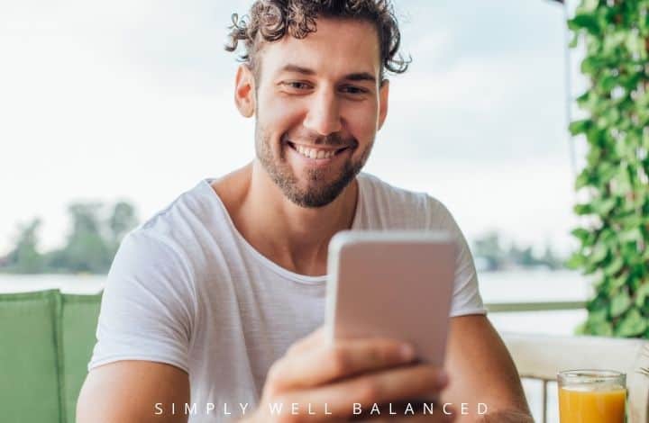 Man reading good morning text message from wife on his cell phone with a smile.