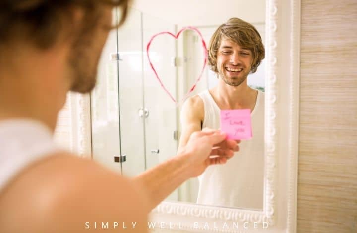Man reading romantic good morning message from wife on mirror in bathroom