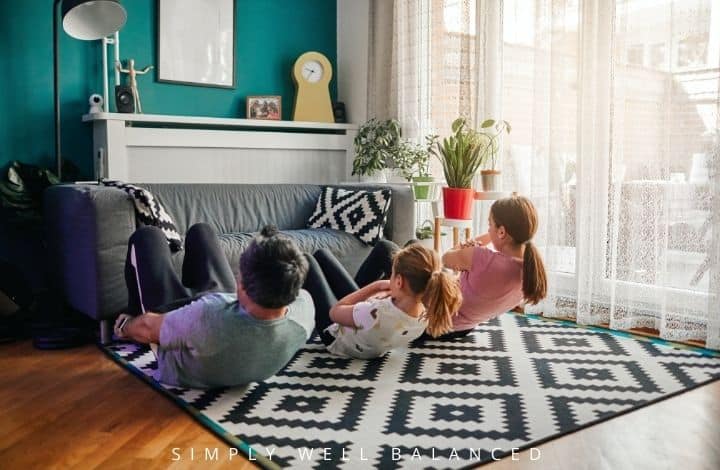 Family working out together in the living room for a family fitness challenge.
