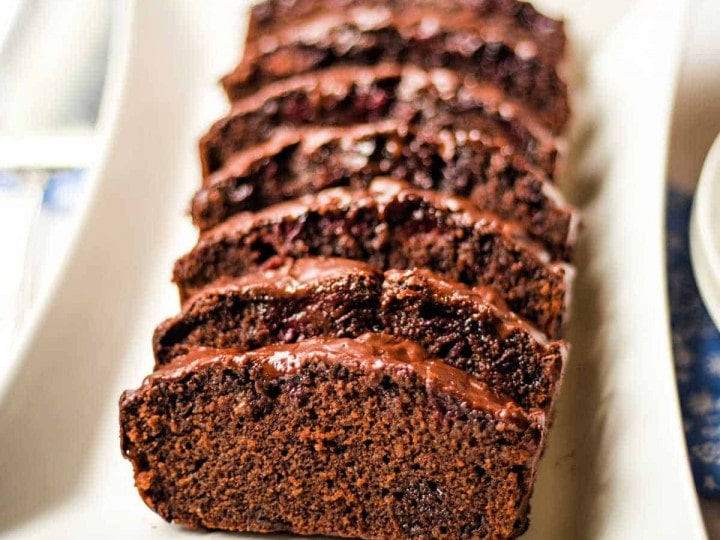 chocolate cherry loaf cake sliced and on a platter