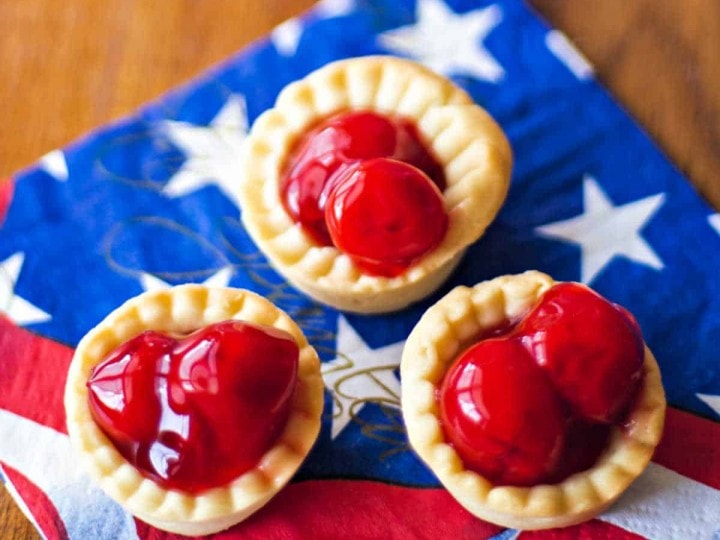 3 bite size cherry tarts on a patriotic napkin