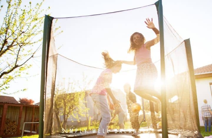 Kids jumping and playing games on a trampoline.