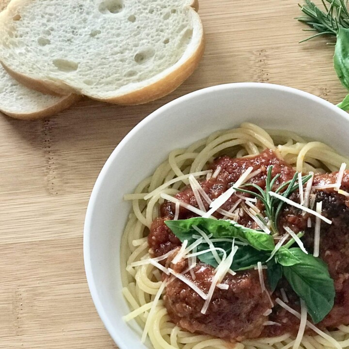 Marinara over pasta with shaved Parmesan Cheese and bread slices