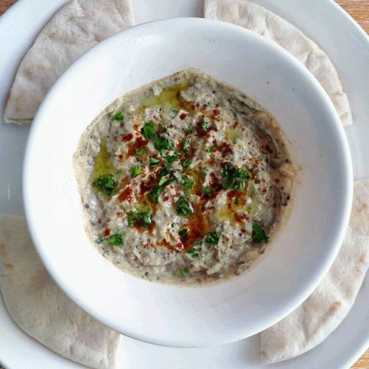 Roasted Aubergine Dip (Baba Ganoush) serve with 4 pieces of flatbread in a plate