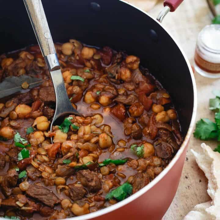 This lamb lentil stew is flavored with Moroccan spices and beefed up with chickpeas. Serve with fresh cilantro and a dollop of yogurt for a hearty and comforting winter meal.