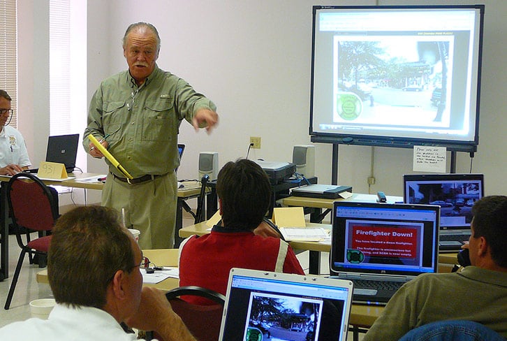 instructor teaching officer development with fire simulator