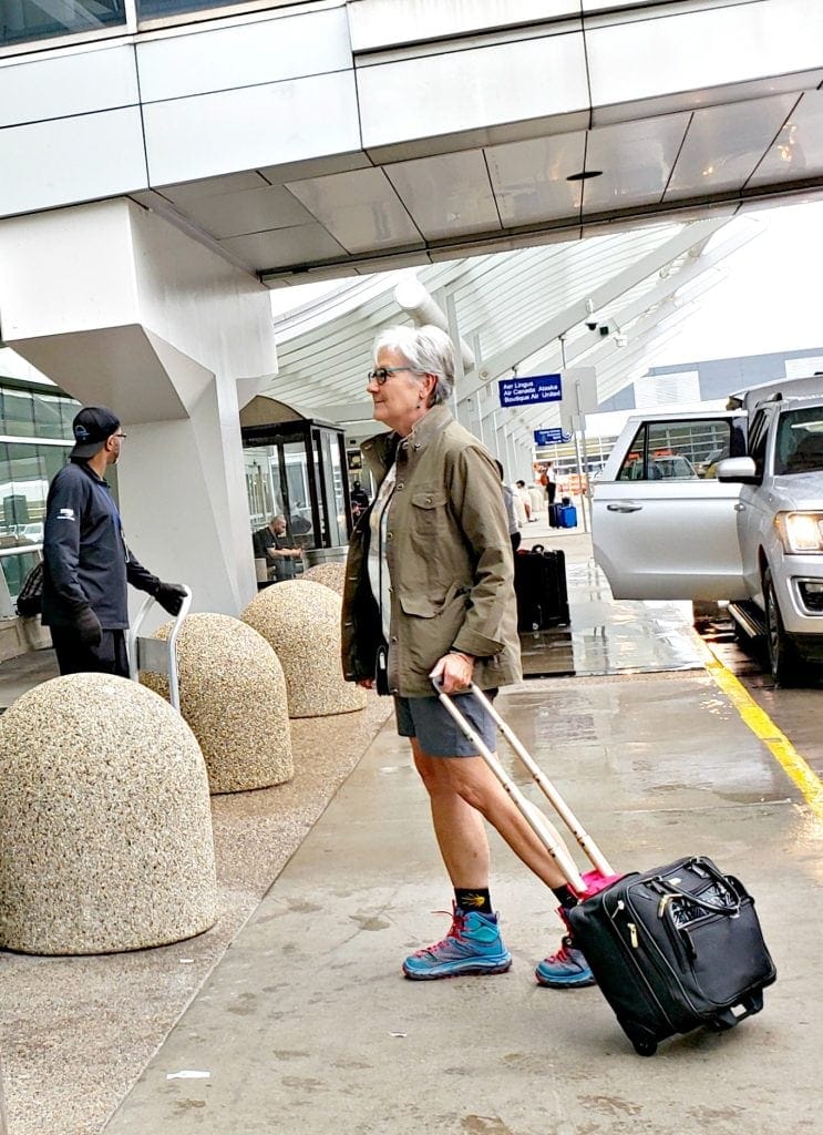 Current photo of author walking into airport with small carry-on that fits under seat.