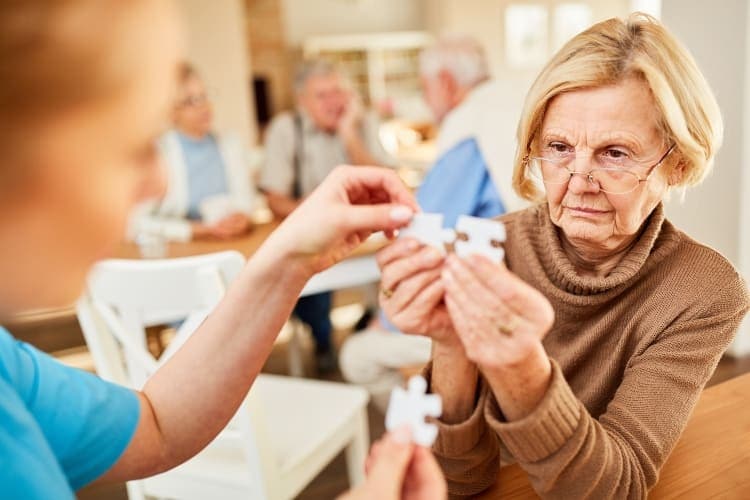 Ältere Frau spielt mit Puzzle
