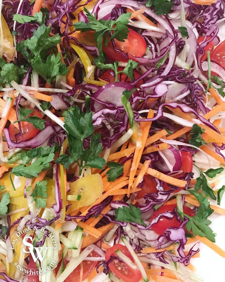 The bright colours of the Rainbow Salad with Spicy Dressing. Tomatoes, red cabbage, carrots, cucumber, parsley, red onion all combined.