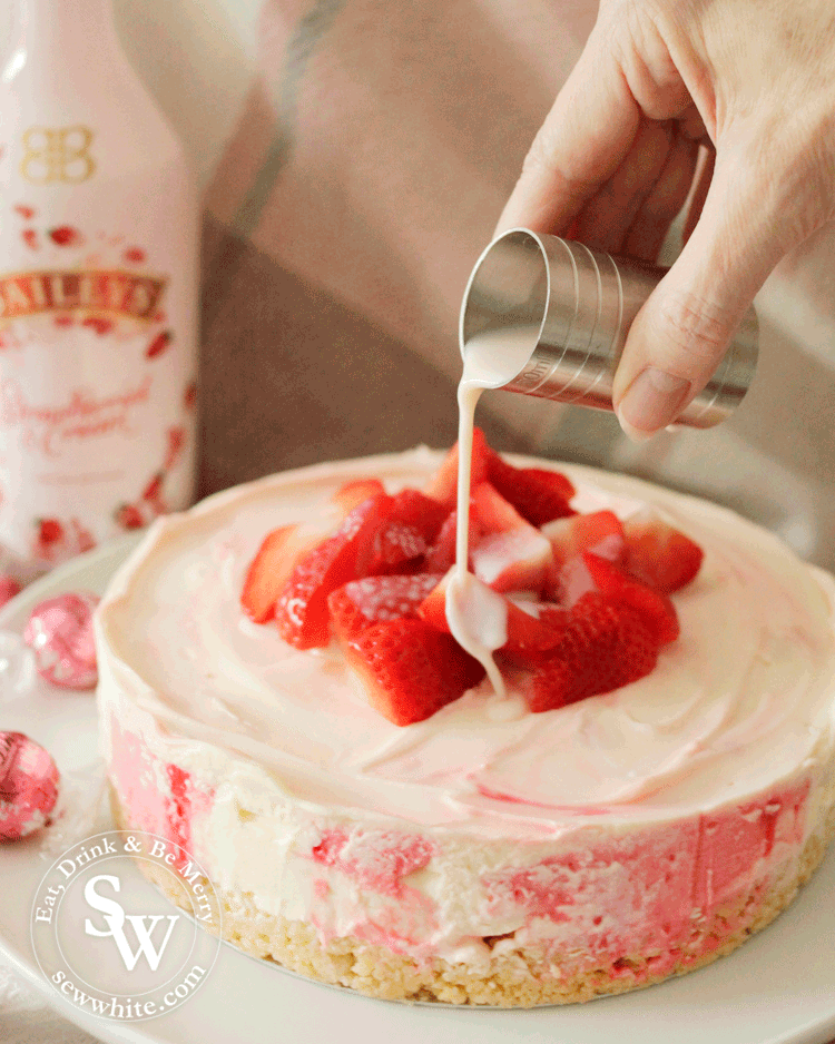 strawberries and cream cheesecake made with Baileys and topped with fresh strawberries.
