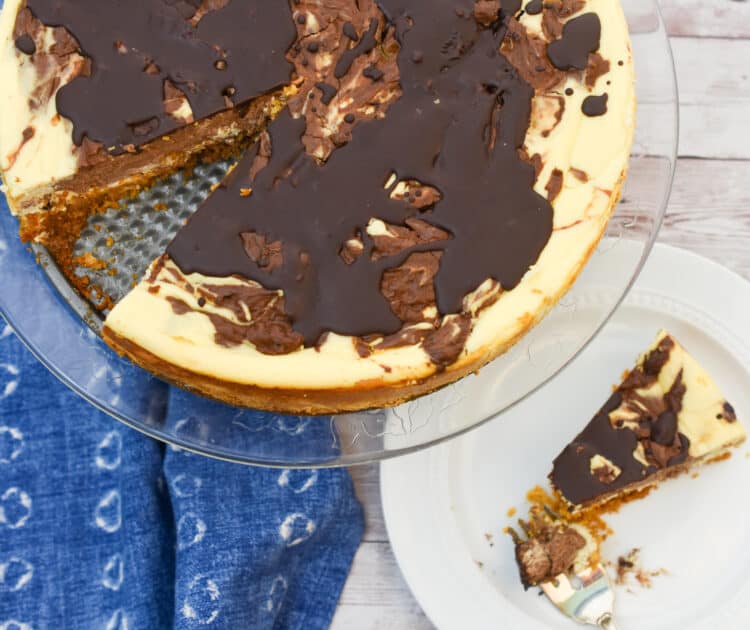 low carb marble cheesecake on cake stand and with a slice next to it.