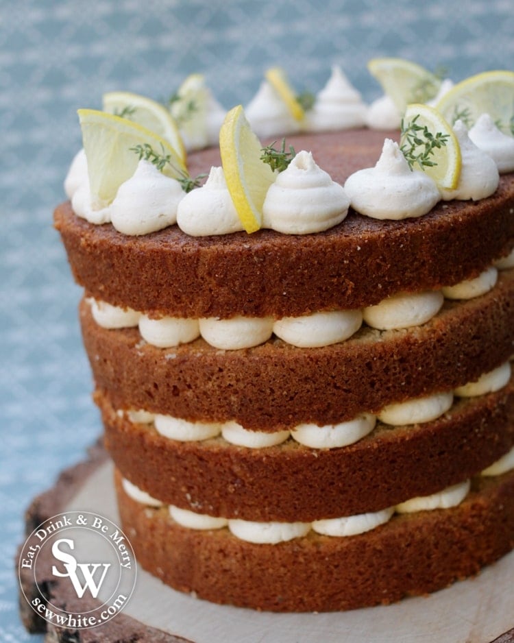 Close up of a naked cake with buttercream centre and decorated with lemon and thyme