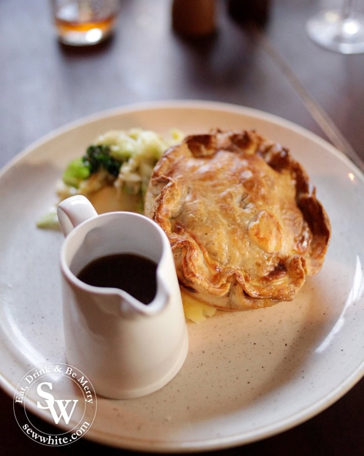 The incredibly impressive golden pastry crust pie served with a little jug of gravy at the Hand in Hand Wimbledon