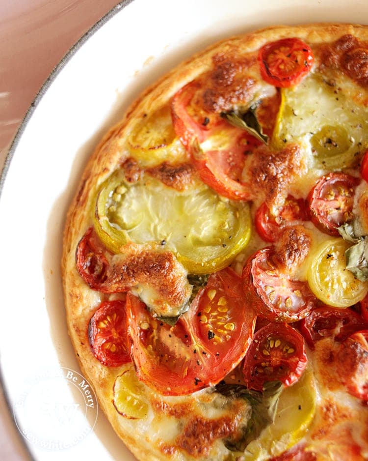 Puff Pastry Tomato Tart with a mix of large and small tomatoes baked with golden brown mozzarella on top.