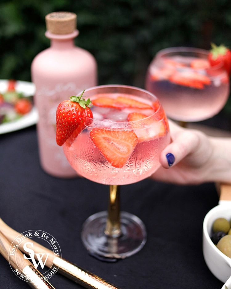 bright pink and red strawberry gin and tonic cocktail in the easy cocktail recipes round up