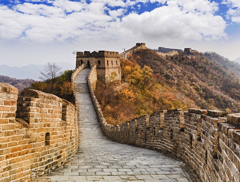 The Great wall of China ancient national architectural landmakrs high in Mutianyu mountains under blue sky tracing away