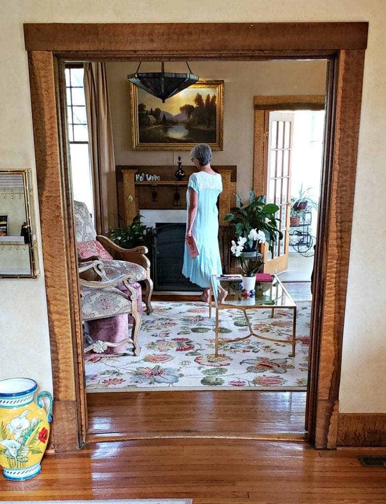 Doorway to parlor frames author standing by fireplace at one of Asheville NC B&Bs