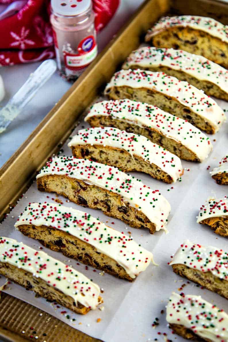 biscotti with white chocolate and sprinkles on a parchment paper lined baking sheet