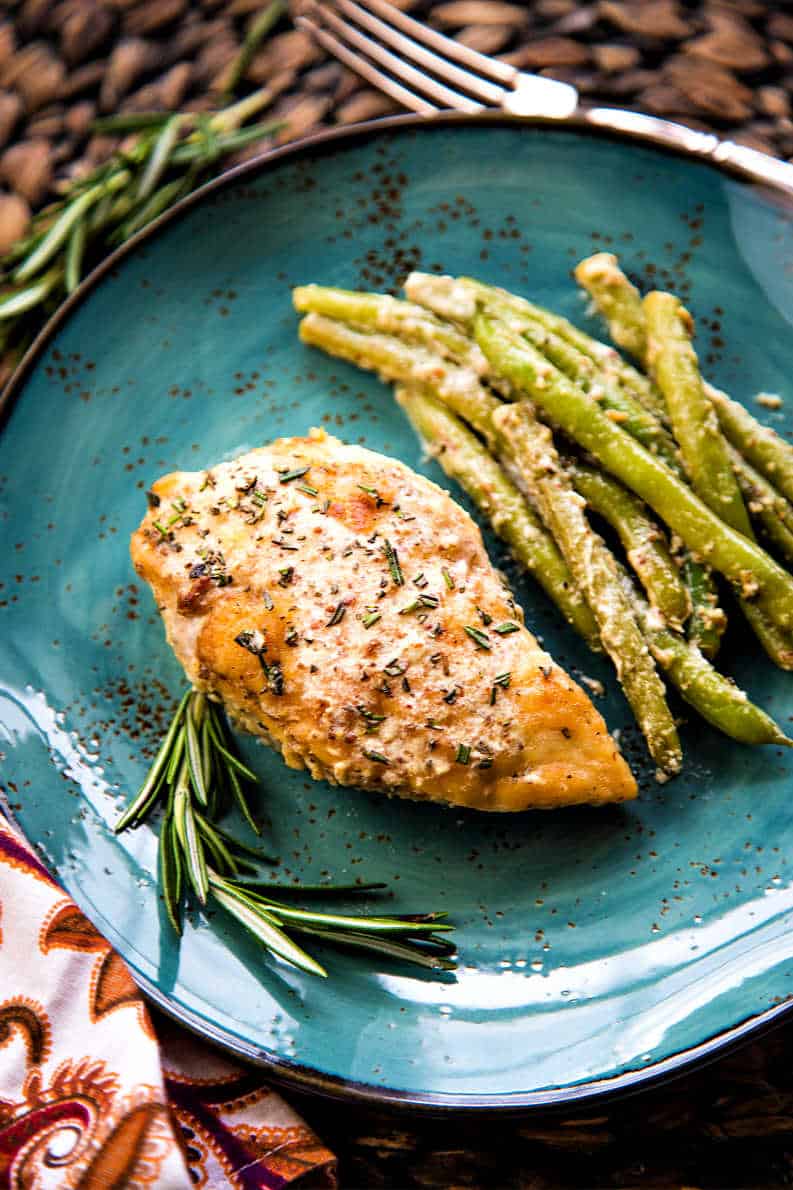 rosemary dijon chicken with whole green beans on a blue plate