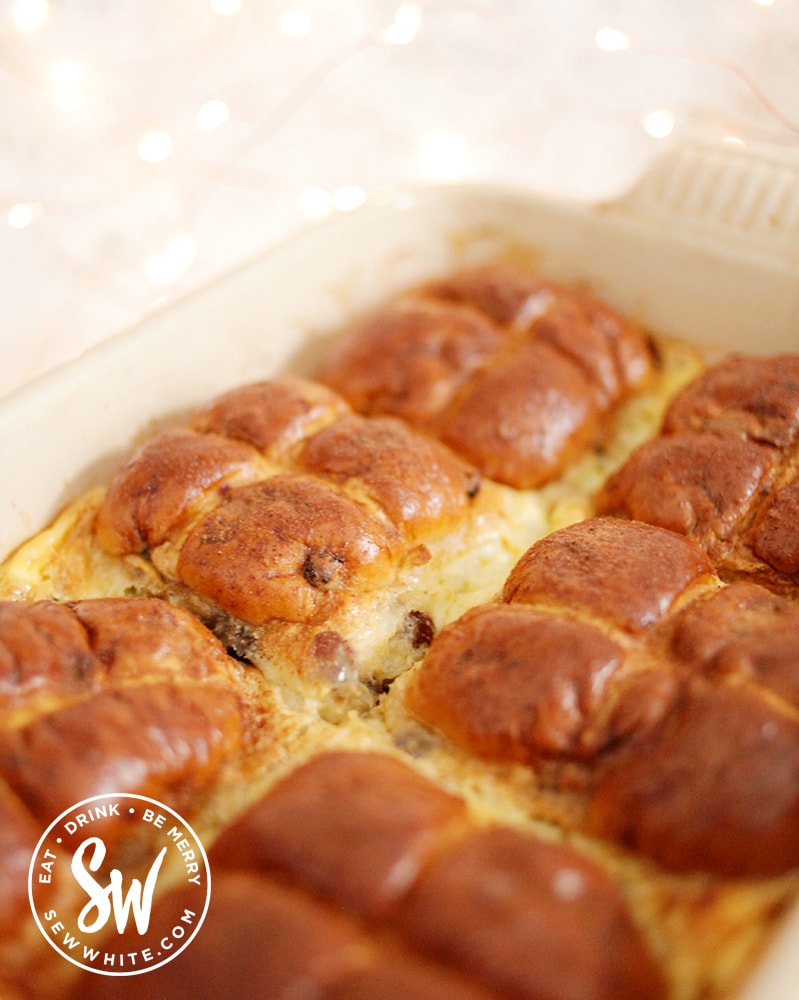 The finished golden brown Hot Cross Bun Dessert with custard and a sprinkle of cinnamon.