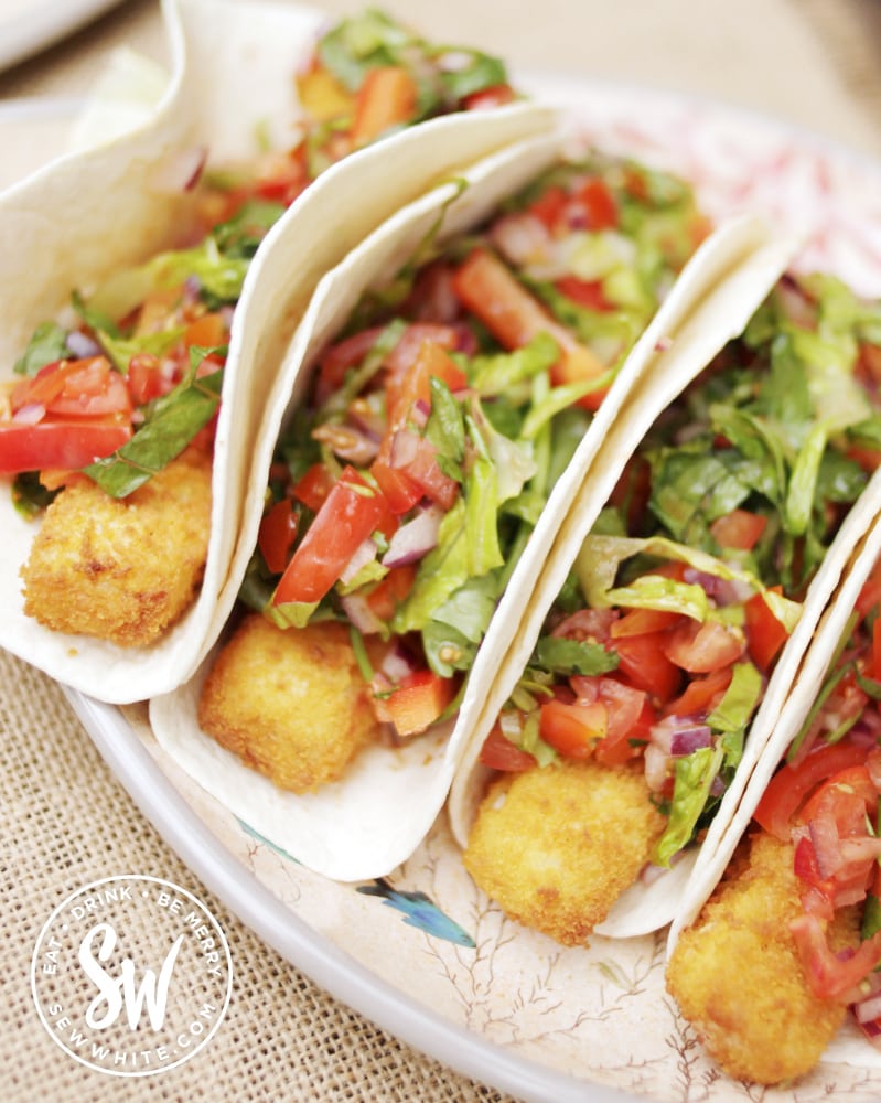 Fish finger tacos in a tortilla wrap with fresh salad salsa.