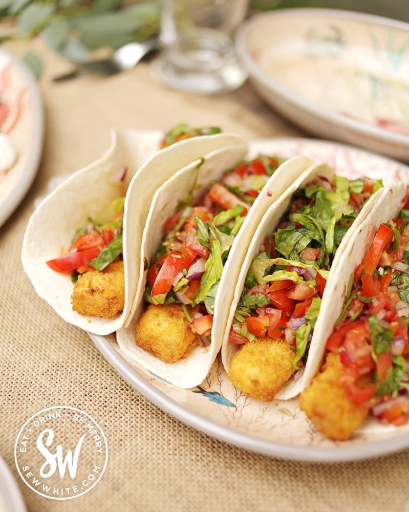 Fish fingers covered with tomato and lettuce in a tortilla for the fish finger burrito