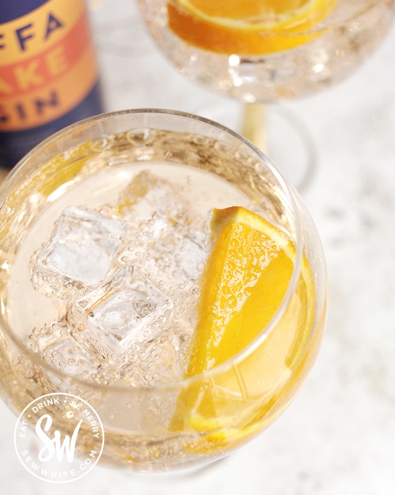 top view of a Jaffa Cake Gin Spritz with ice cubes and slice of orange