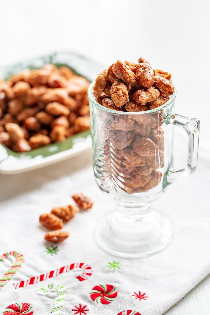 Burnt Sugar Almonds (Gebrannte Mandeln) - a traditional German recipe for delicious cinnamon sugar coated almonds like those you'll find in a Christkindlmarkt around the holidays. #savingroomfordessert #burntsugaralmonds #almonds #candiedalmonds #cinnamonalmonds #holidaygifts #ediblegifts #germanalmonds #gebranntemandeln a cup of burnt sugar cinnamon almonds