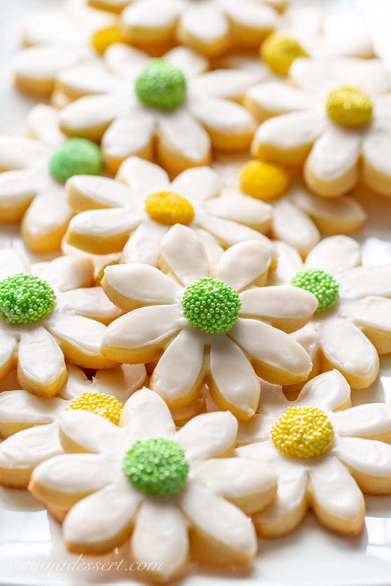 Everybody needs a great sugar cookie recipe that's easy to make, tastes fantastic, and one that holds its shape when baked. This is the recipe! #sugarcookie #sugarcookierecipe #sugarcookiesrecipe #homemadesugarcookies #howtomakesugarcookies #cutoutcookies #cutoutsugarcookies Thick flower shaped cut-out sugar cookies decorated with yellow and green sprinkles
