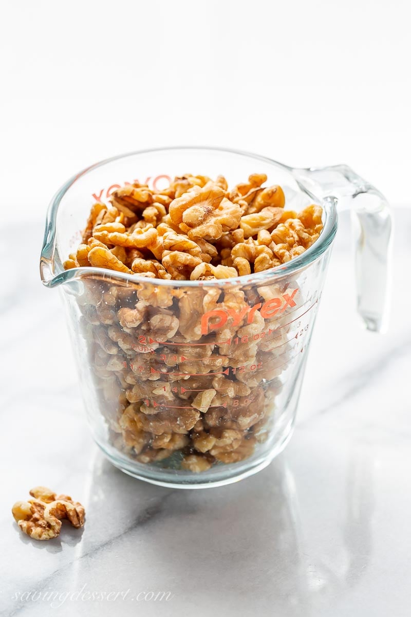 A measuring cup filled with walnut halves
