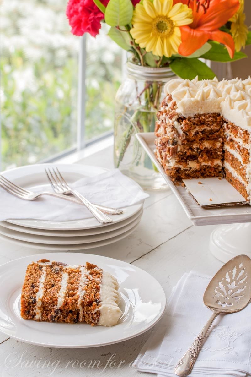 a slice of carrot cake with toasted pecans and cream cheese icing