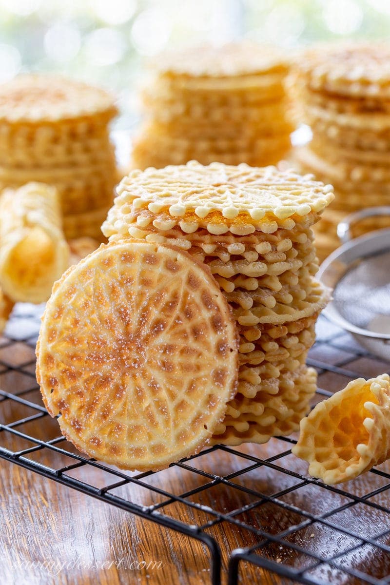 A stack of anise flavored pizzelle cookies on a cooling rack