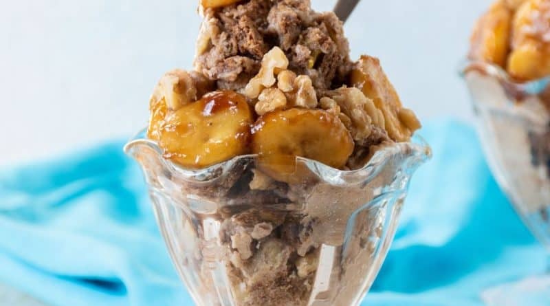 Sundae dish with nice cream topped with caramelized bananas and walnuts