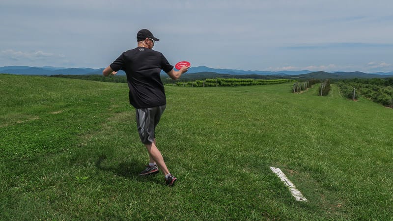 Buddy throwing his first disc at the disc golf course at Chattooga Belle Farm