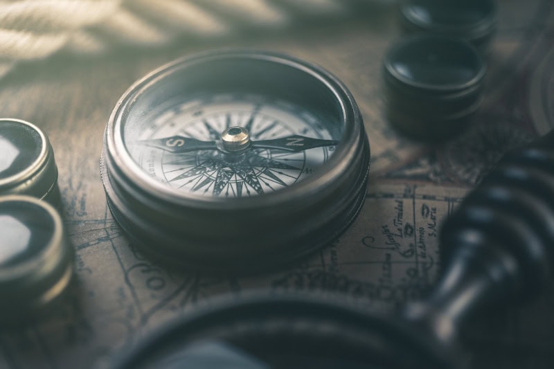 A vintage compass lying on a map.