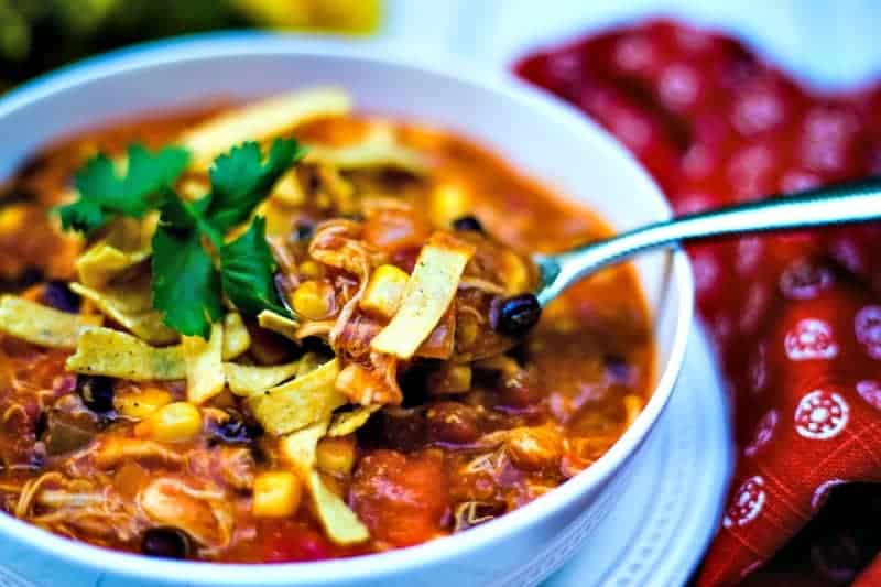 A bowl of food on a plate, with Chicken Tortilla Soup