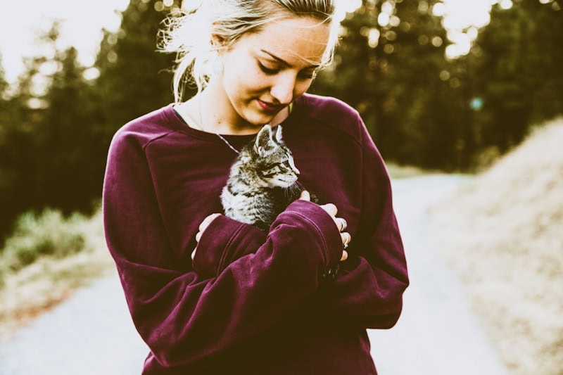 Image of a beautiful girl walking on a trail with her cat