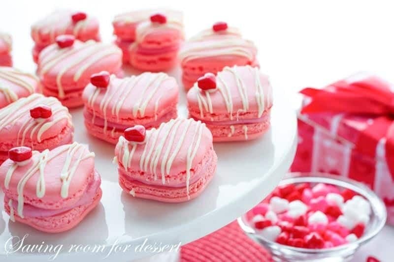 Raspberry Macarons - simple heart shaped macarons using the Italian method, with tips, tricks and how-to instructions for the best cookies. Filled with a fresh raspberry buttercream and topped with a drizzle of white chocolate. Great for Valentine's Day! www.savingdessert.com