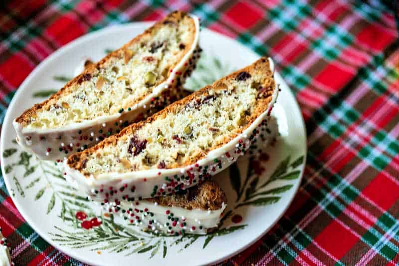 a plate of cranberry pistachio biscotti on a red tartan plaid tablecloth