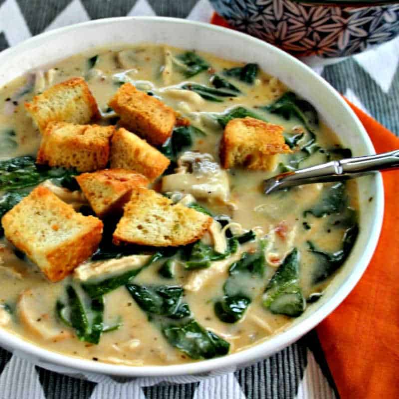 a bowl of chicken florentine soup with toasted croutons