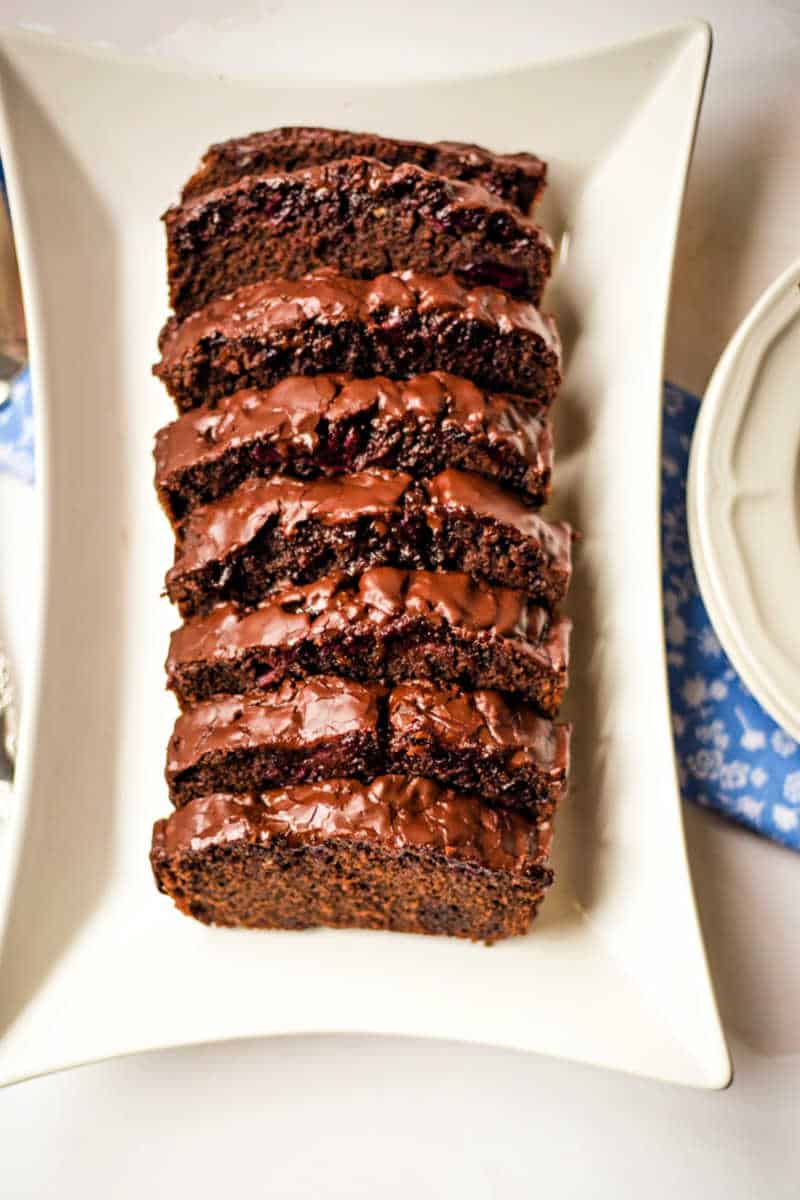 chocolate cherry loaf cake sliced and on a platter