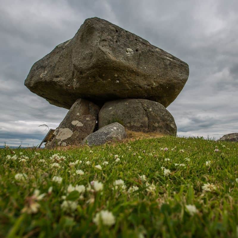 An ancient megalith or dolmen with a large capstone supported by three smaller stones