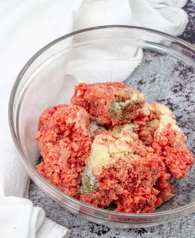 ground beef, onion powder, garlic powder, salt and pepper mixed together in a bowl