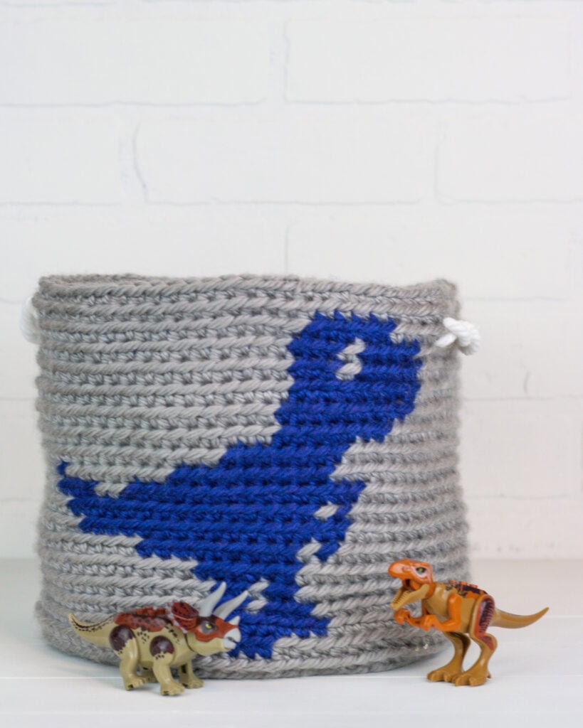 Quick and easy dinosaur basket crochet pattern by Winding Road Crochet with video guide.
