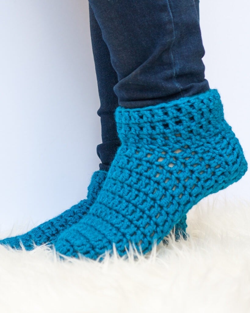 Want to make a pair of warm and cozy socks? This free pattern and video tutorial will teach you how to crochet slipper socks in under an hour.