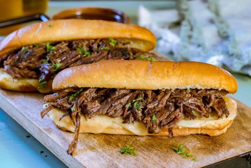 These flavorful Easy Crock Pot French Dip Sandwiches are a family favorite. Top them with provolone cheese and serve with a side of au jus. This Slow Cooker French Dip Sandwich recipe is perfect for a weeknight meal or to serve at a game day party or casual get together. This is an easy sandwich recipe that everyone will enjoy. #frenchdip #slowcookerrecipe #crockpotrecipe #slowcookerfrenchdip