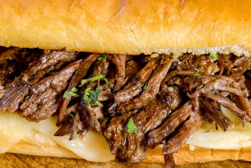 These flavorful Easy Crock Pot French Dip Sandwiches are a family favorite. Top them with provolone cheese and serve with a side of au jus. This Slow Cooker French Dip Sandwich recipe is perfect for a weeknight meal or to serve at a game day party or casual get together. This is an easy sandwich recipe that everyone will enjoy. #frenchdip #slowcookerrecipe #crockpotrecipe #slowcookerfrenchdip