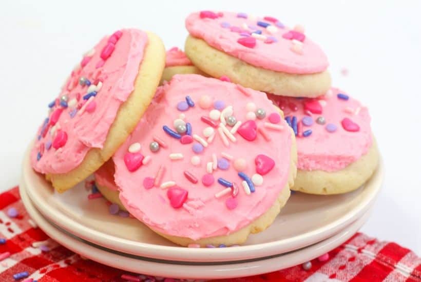 These soft and buttery Valentine Lofthouse Sugar Cookies are the perfect sweet treat. These sour cream cookies are topped with sweet frosting and sprinkles. This is an easy sugar cookie recipe that requires no rolling. You can make them for any season or holiday by just changing the color of the frosting. #sugarcookies #lofthousecookies #valentinesdayrecipe #partyidea