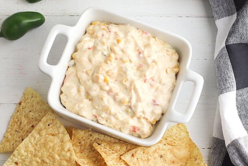 This Cheesy Slow Cooker Fiesta Corn Dip is a creamy, cheesy dip recipe that's perfect for any party. It's great for tailgating, too!